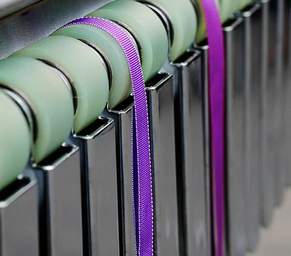 Finished webbing passing through rollers